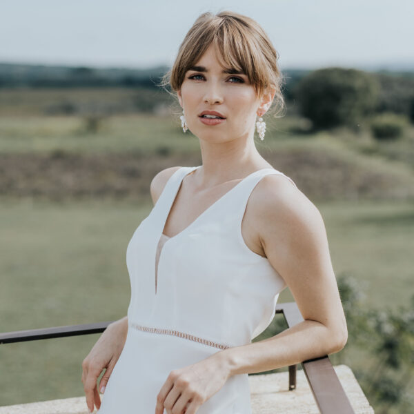 jeune mariée portant une paire de boucles d'oreilles de mariage faite d'une grappe de perles d'eau douce et de perles de porcelaine.
