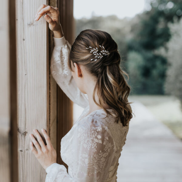 Accessoires cheveux de mariage en nacre et perles de Swarovski, portés par un mariée. Ces bijoux de mariage sont composés d'épingles à chignon.