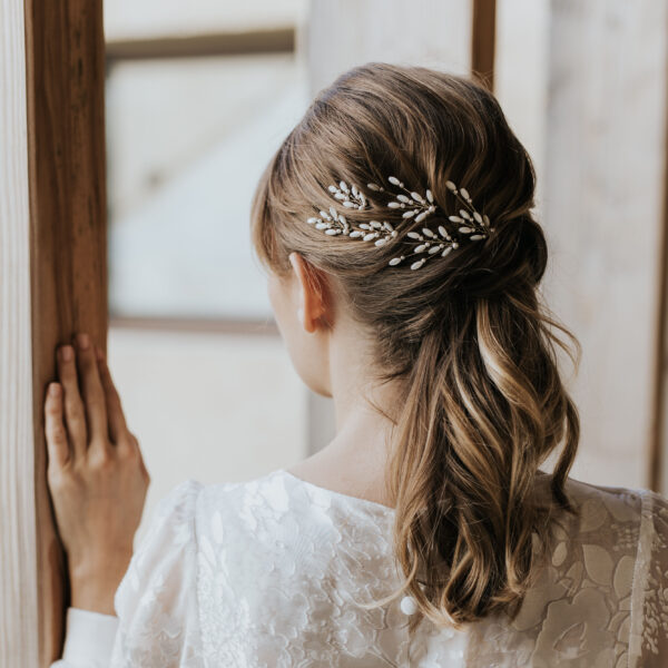 Accessoires cheveux de mariage en nacre et perles de Swarovski, portés par un mariée. Ces bijoux de mariage sont composés d'épingles à chignon.