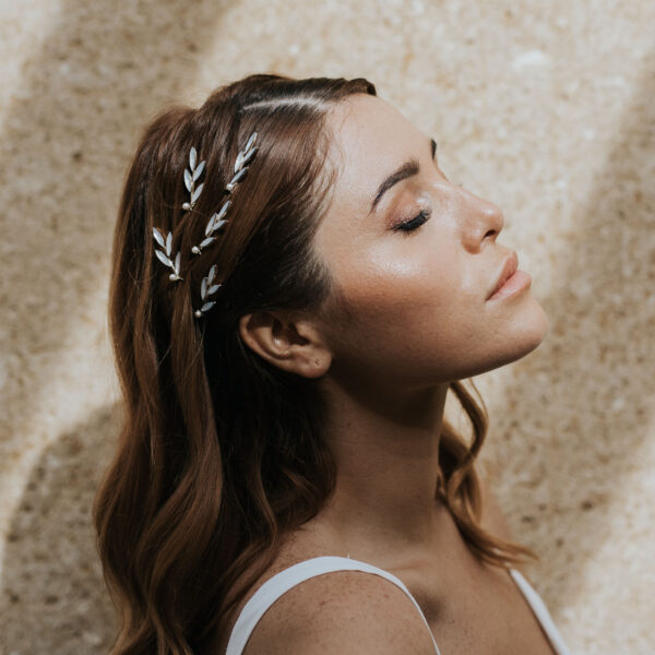 coiffure de mariée cheveux détachés, habillée de bijoux de mariage strassés et brillants avec des petites perles.