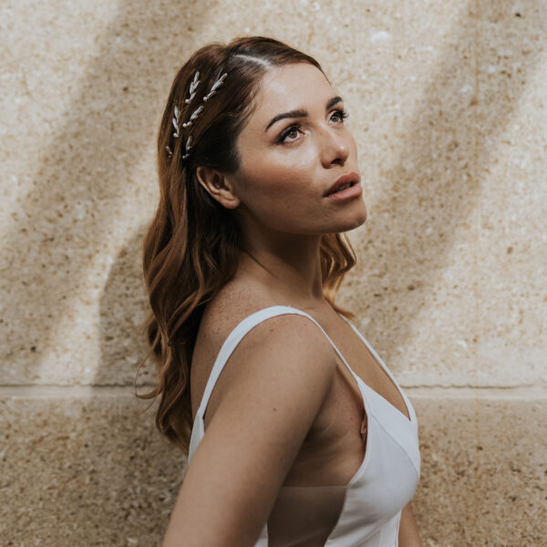 coiffure de mariée cheveux détachés, habillée de bijoux de mariage strassés et brillants avec des petites perles.