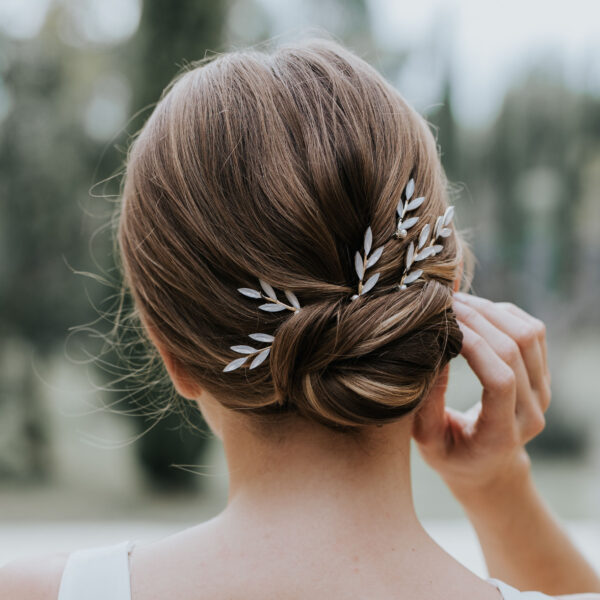 Mariée avec un chignon, rehaussé de fines épingles à cheveux strassées.